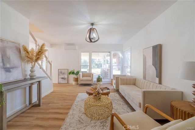 living room featuring a wall unit AC and light wood finished floors