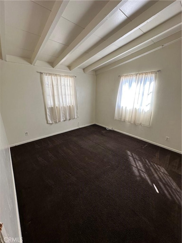 empty room with baseboards, dark colored carpet, and beamed ceiling