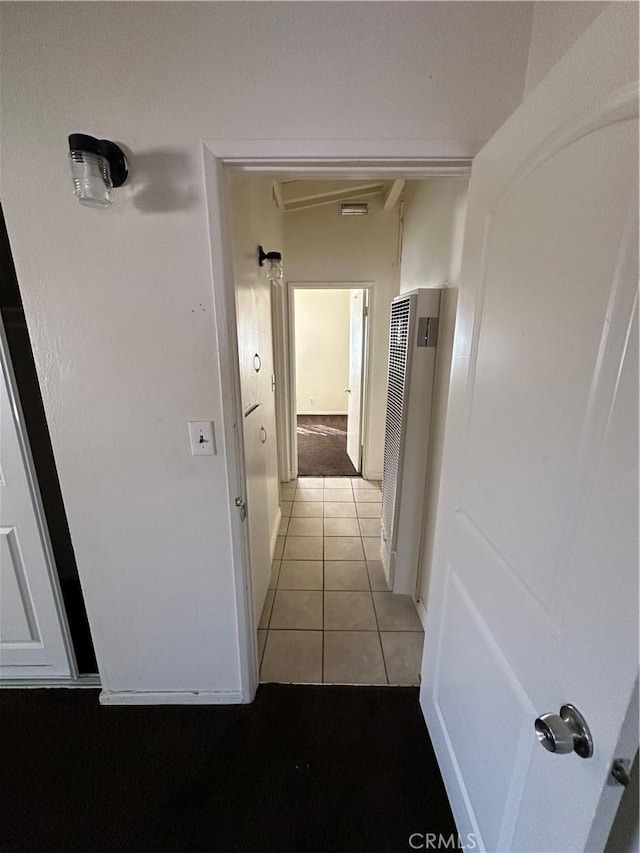 hall with a heating unit and light tile patterned floors