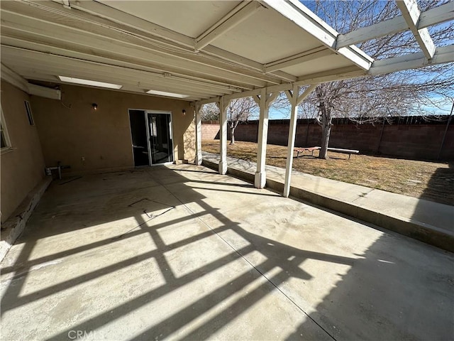 view of patio / terrace featuring driveway, fence, and a carport