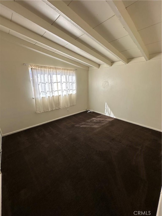 empty room with baseboards, dark carpet, and beam ceiling