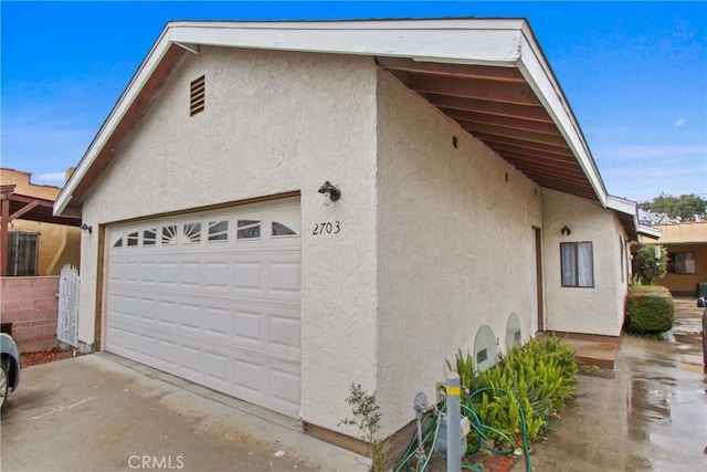 view of side of property with stucco siding and a garage