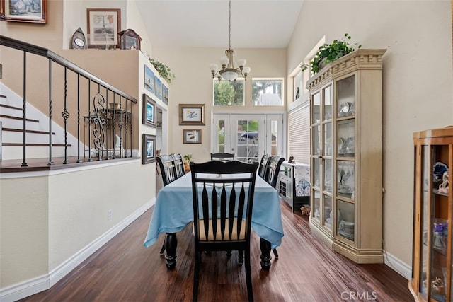 dining room featuring baseboards, wood finished floors, stairway, and an inviting chandelier