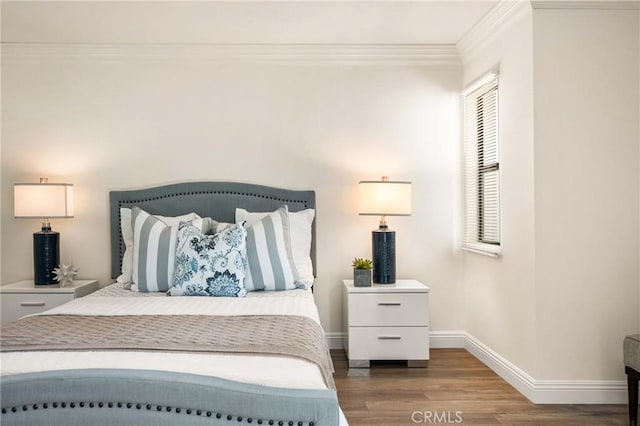 bedroom with baseboards, ornamental molding, and wood finished floors