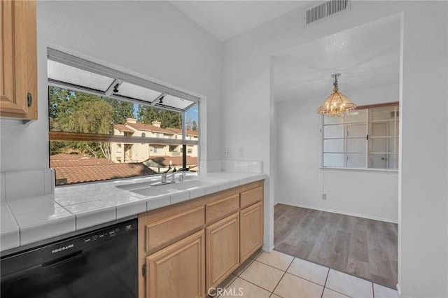 kitchen featuring a chandelier, tile counters, visible vents, a sink, and black dishwasher