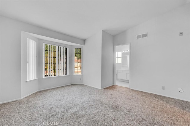 spare room with baseboards, carpet flooring, and visible vents