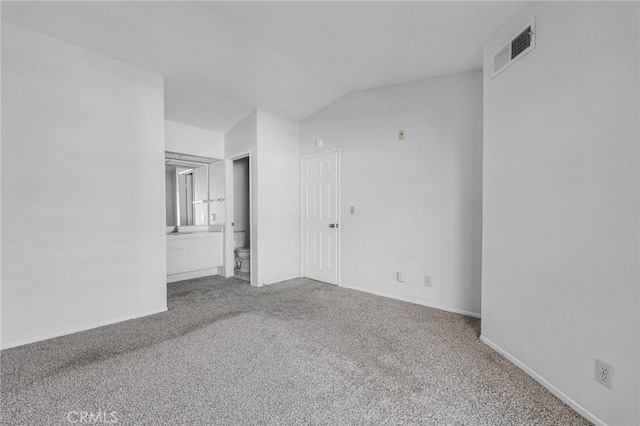 carpeted spare room with lofted ceiling and visible vents