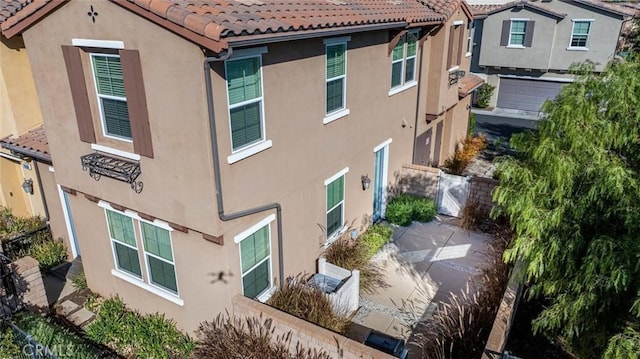 view of home's exterior with a tile roof and stucco siding