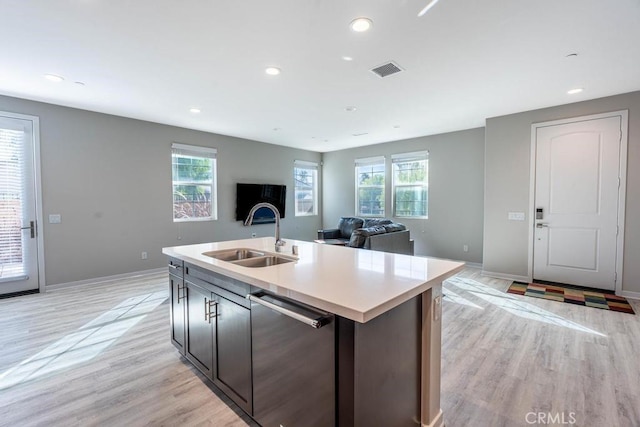 kitchen with dishwasher, plenty of natural light, open floor plan, and a sink