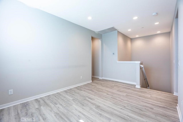 empty room with recessed lighting, baseboards, and wood finished floors