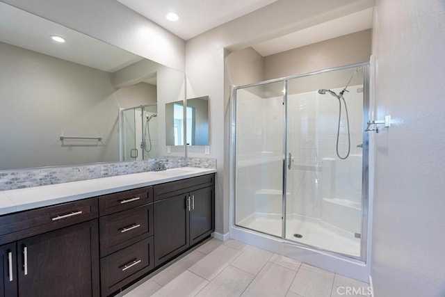 bathroom featuring a stall shower, vanity, and recessed lighting