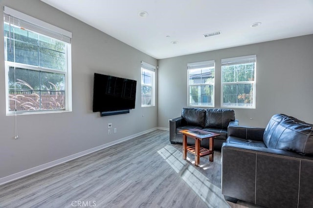 living area with light wood finished floors, plenty of natural light, visible vents, and baseboards