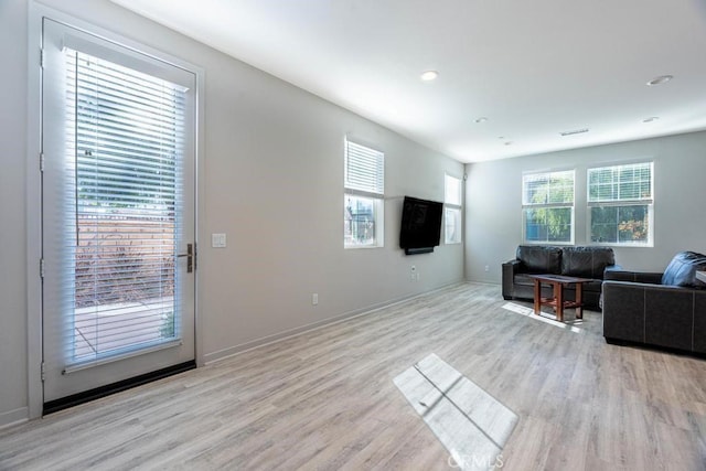 living room with light wood-type flooring, baseboards, and recessed lighting