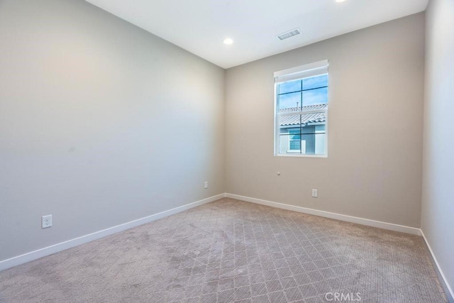 empty room with light colored carpet, visible vents, baseboards, and recessed lighting