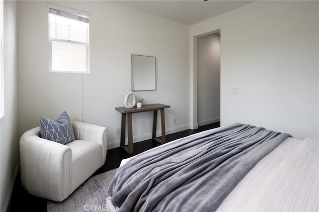 bedroom with baseboards and wood finished floors