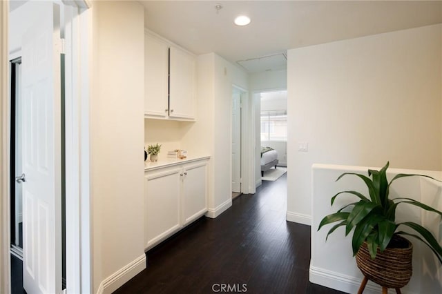 corridor featuring baseboards, dark wood-style flooring, and recessed lighting