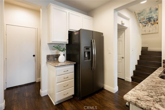 kitchen with light stone counters, dark wood-style flooring, white cabinetry, and stainless steel fridge with ice dispenser