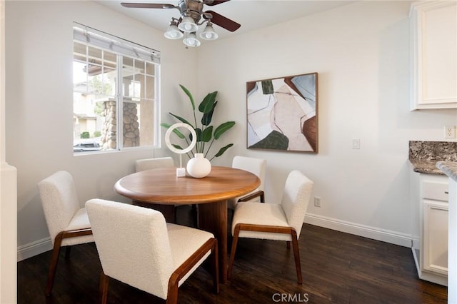 dining space with ceiling fan, baseboards, and dark wood finished floors