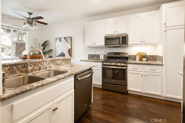 kitchen with stainless steel appliances, white cabinets, dark wood-type flooring, and a sink