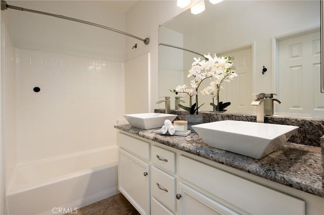 bathroom featuring shower / bathtub combination, double vanity, tile patterned flooring, and a sink