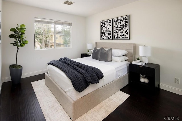 bedroom featuring dark wood finished floors, visible vents, and baseboards