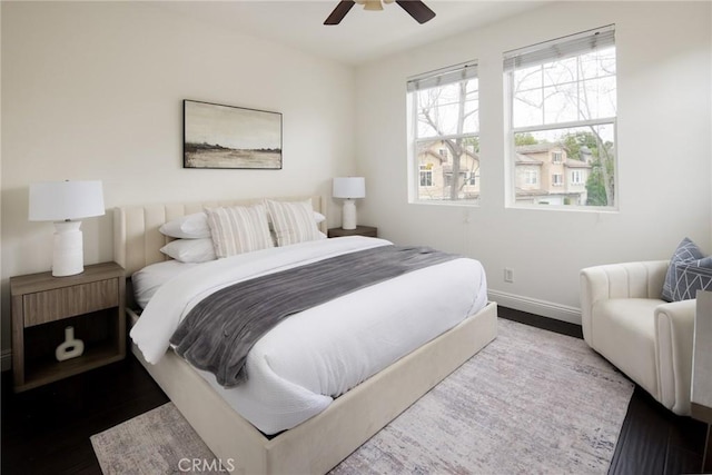 bedroom with ceiling fan, baseboards, and wood finished floors