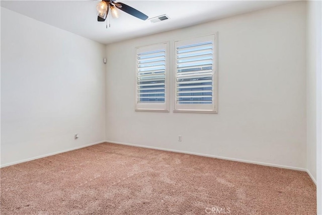 carpeted empty room featuring baseboards, visible vents, and a ceiling fan