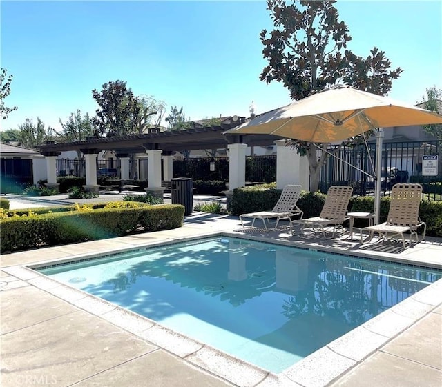 community pool with a pergola, a patio, and fence