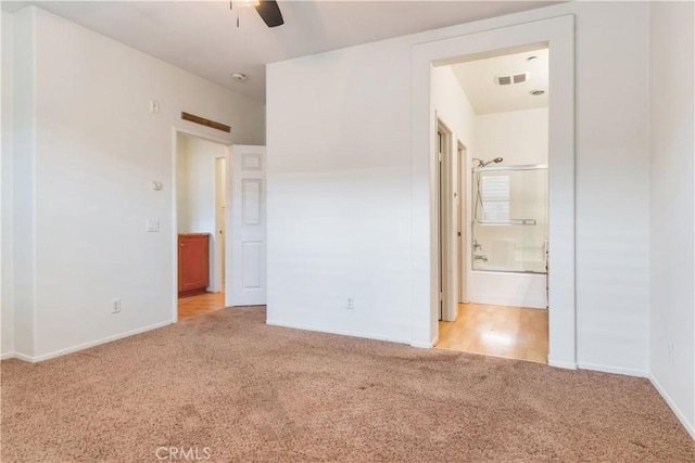 unfurnished bedroom featuring carpet floors, visible vents, connected bathroom, and baseboards