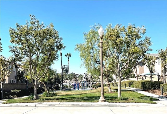 view of community with a lawn and fence