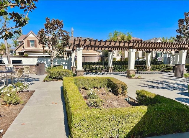 view of home's community with area for grilling, fence, and a pergola