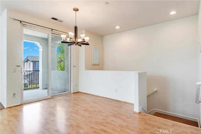 spare room featuring visible vents, a chandelier, wood finished floors, and recessed lighting