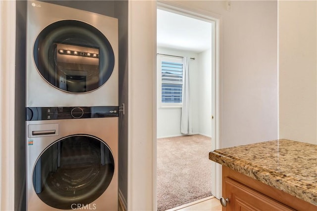 laundry area with light carpet, laundry area, and stacked washer and clothes dryer