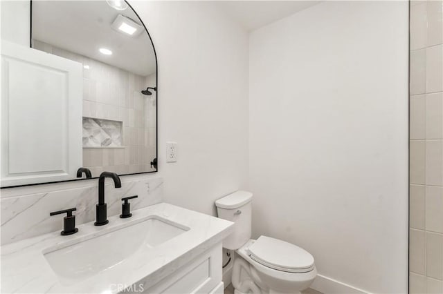 bathroom with tasteful backsplash, vanity, and toilet