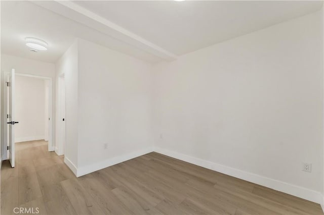 unfurnished room with baseboards and light wood-style floors