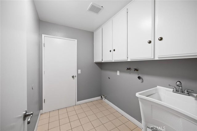 laundry room featuring light tile patterned floors, baseboards, visible vents, cabinet space, and a sink