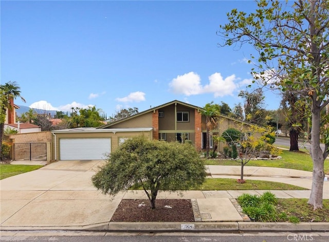 mid-century modern home featuring an attached garage, driveway, and fence