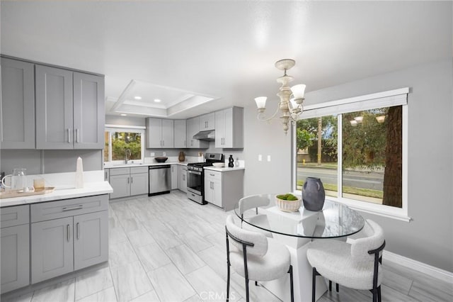 dining area featuring a raised ceiling, recessed lighting, baseboards, and a chandelier