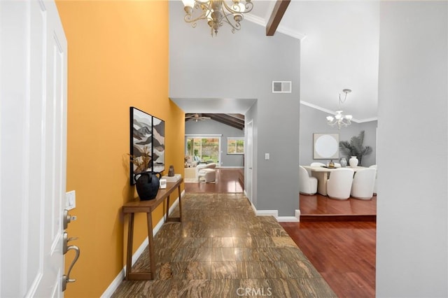 foyer entrance featuring wood finished floors, high vaulted ceiling, baseboards, and ornamental molding