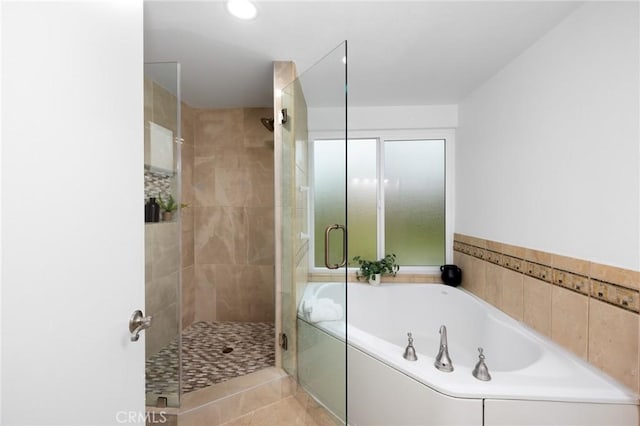 full bath featuring a stall shower and a garden tub