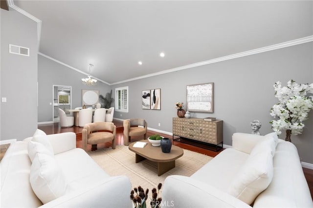 living room featuring wood finished floors, visible vents, lofted ceiling, ornamental molding, and a notable chandelier