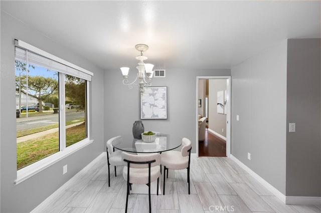 dining area with an inviting chandelier, visible vents, and baseboards