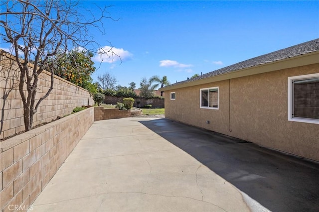 view of property exterior featuring a fenced backyard, stucco siding, and a patio