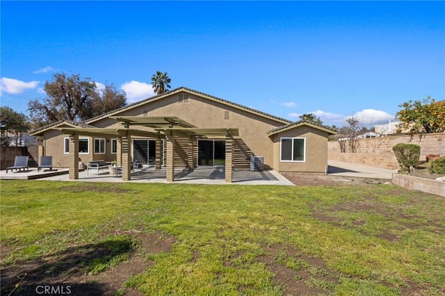 back of house featuring fence, stucco siding, a yard, a patio area, and a pergola