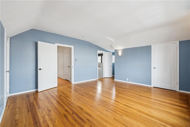 bonus room with light wood finished floors, baseboards, and vaulted ceiling