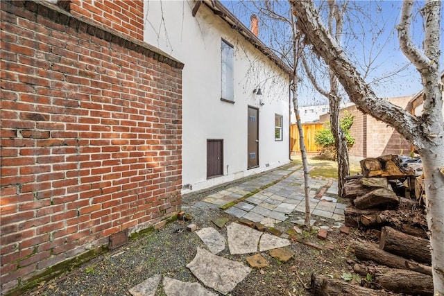 exterior space with a patio, brick siding, and stucco siding