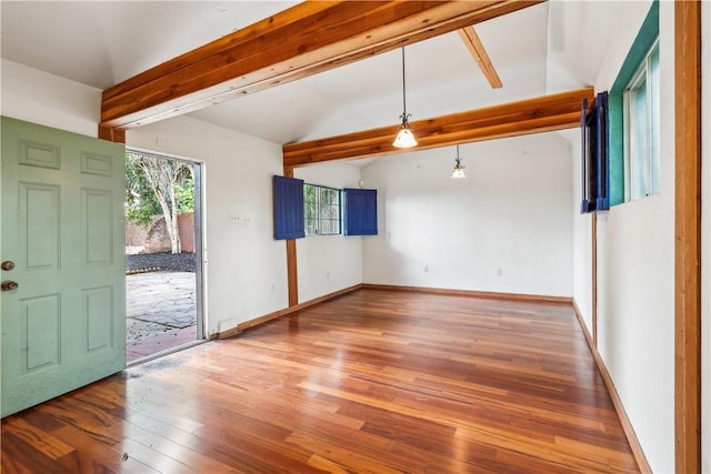 spare room with lofted ceiling with beams, wood finished floors, and baseboards