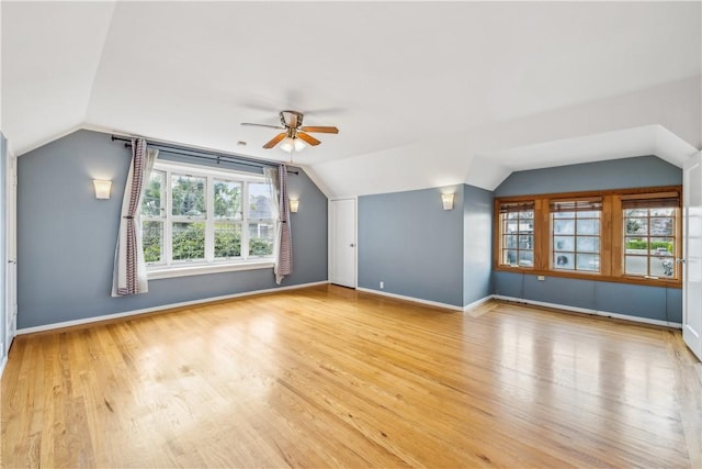 bonus room with lofted ceiling, wood finished floors, a ceiling fan, and baseboards