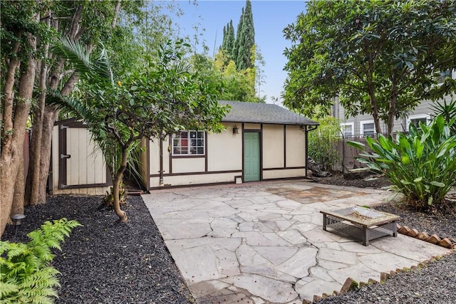 view of patio / terrace with an outbuilding and fence