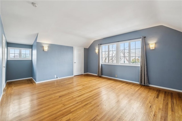 bonus room with vaulted ceiling, light wood finished floors, and baseboards